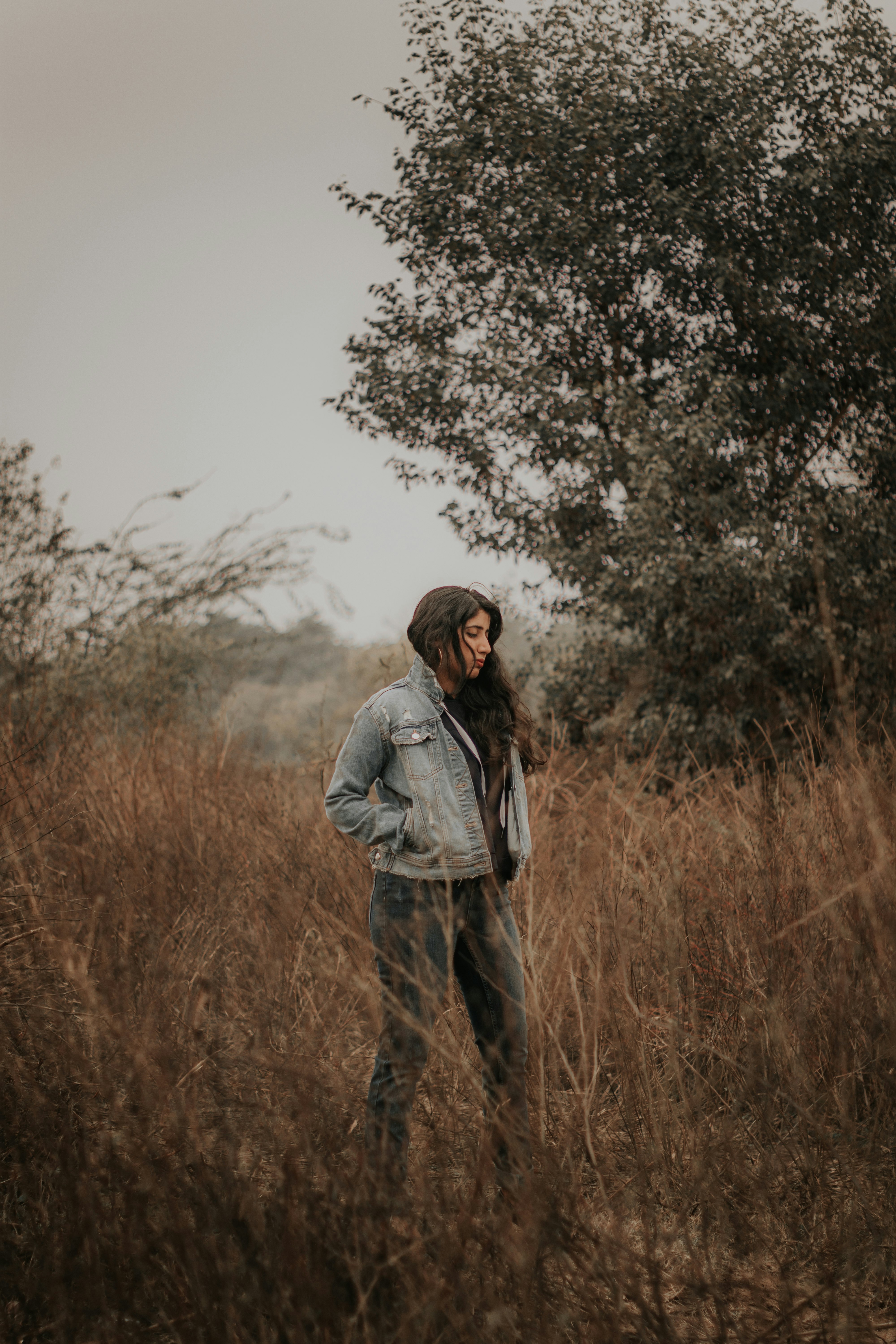 man in gray jacket standing on brown grass field during daytime